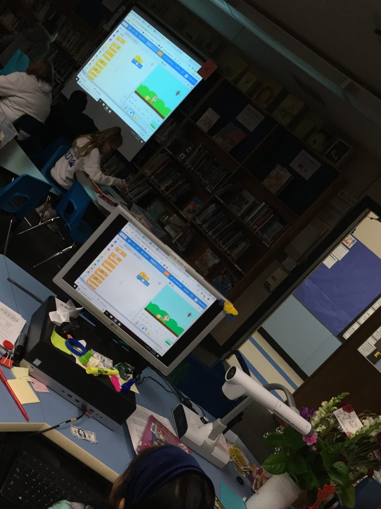A student shares her coding with classmates